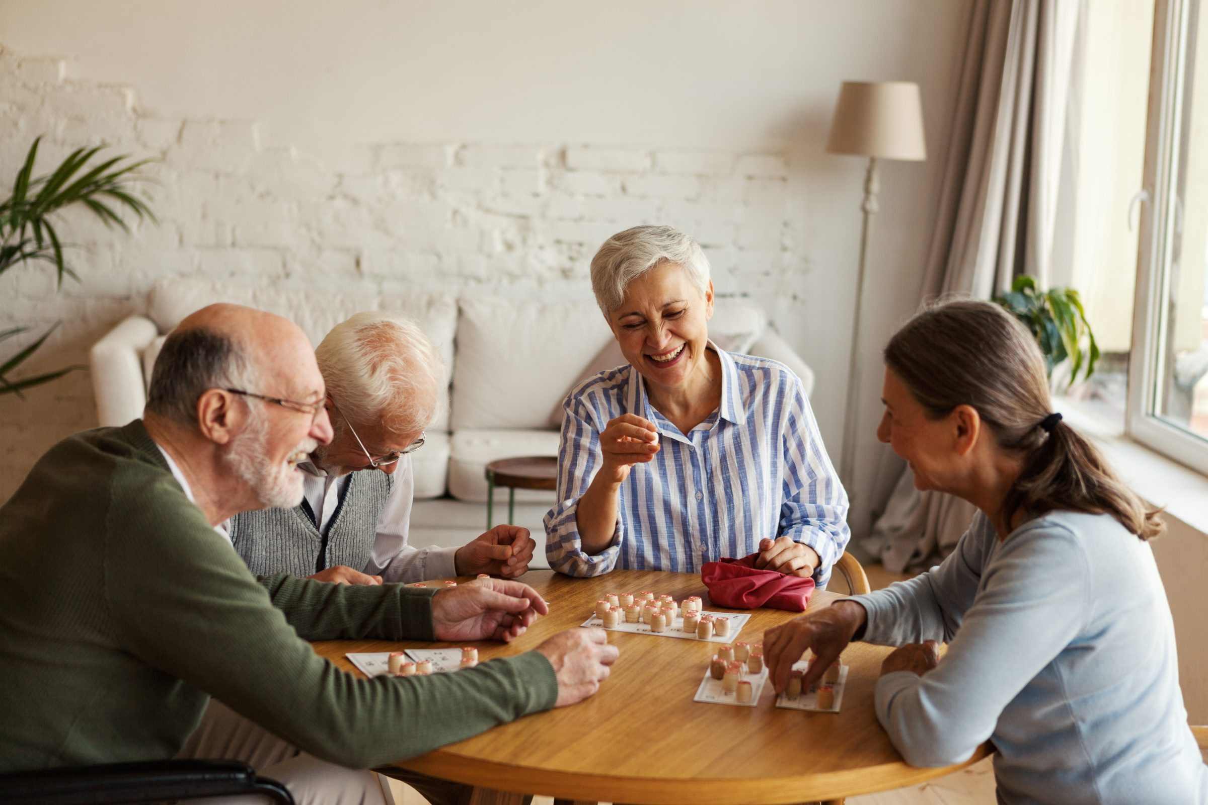 Residents and a caregiver playing cards at a table
