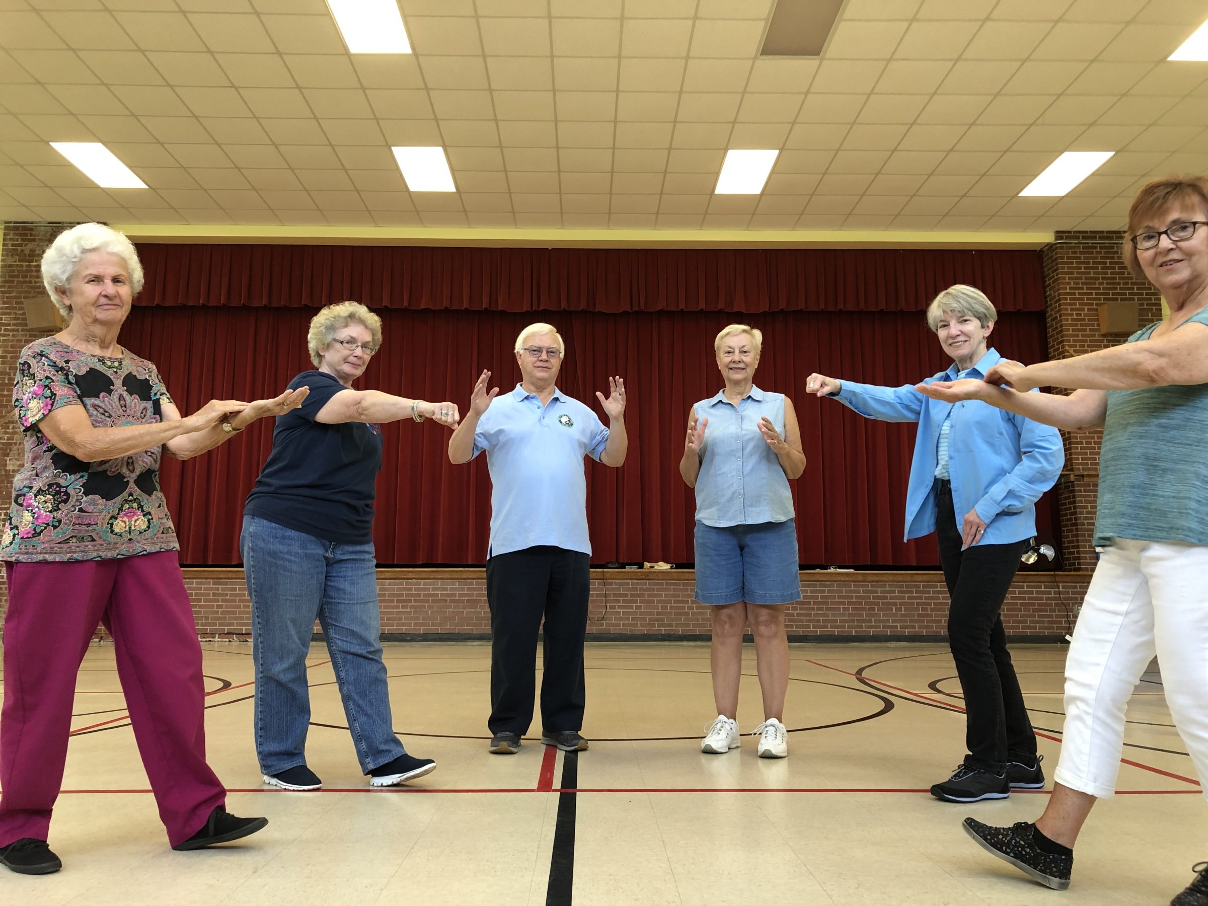 Older adults practicing tai chi in a community gym