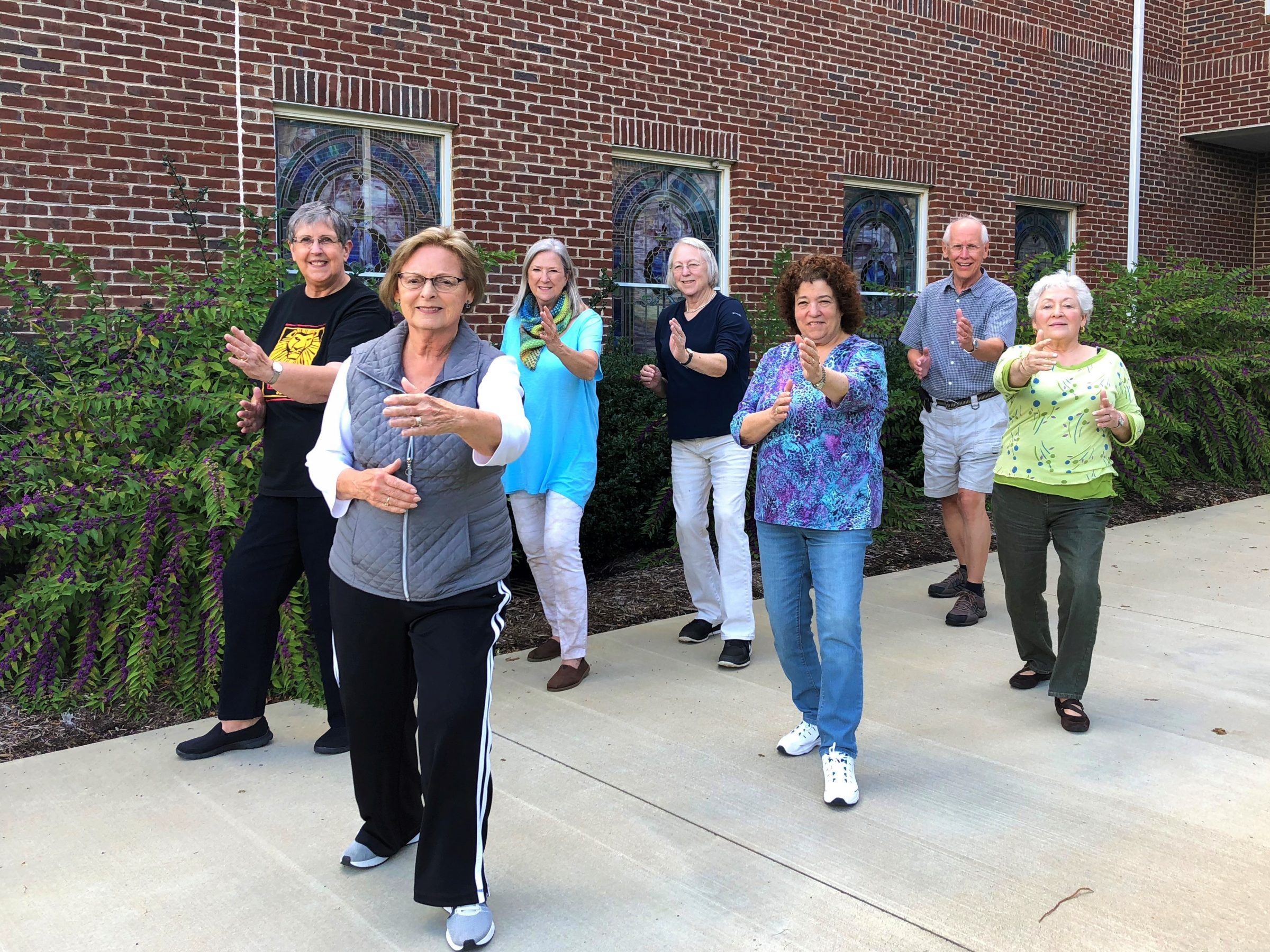 A group of older adults exercising together outdoors
